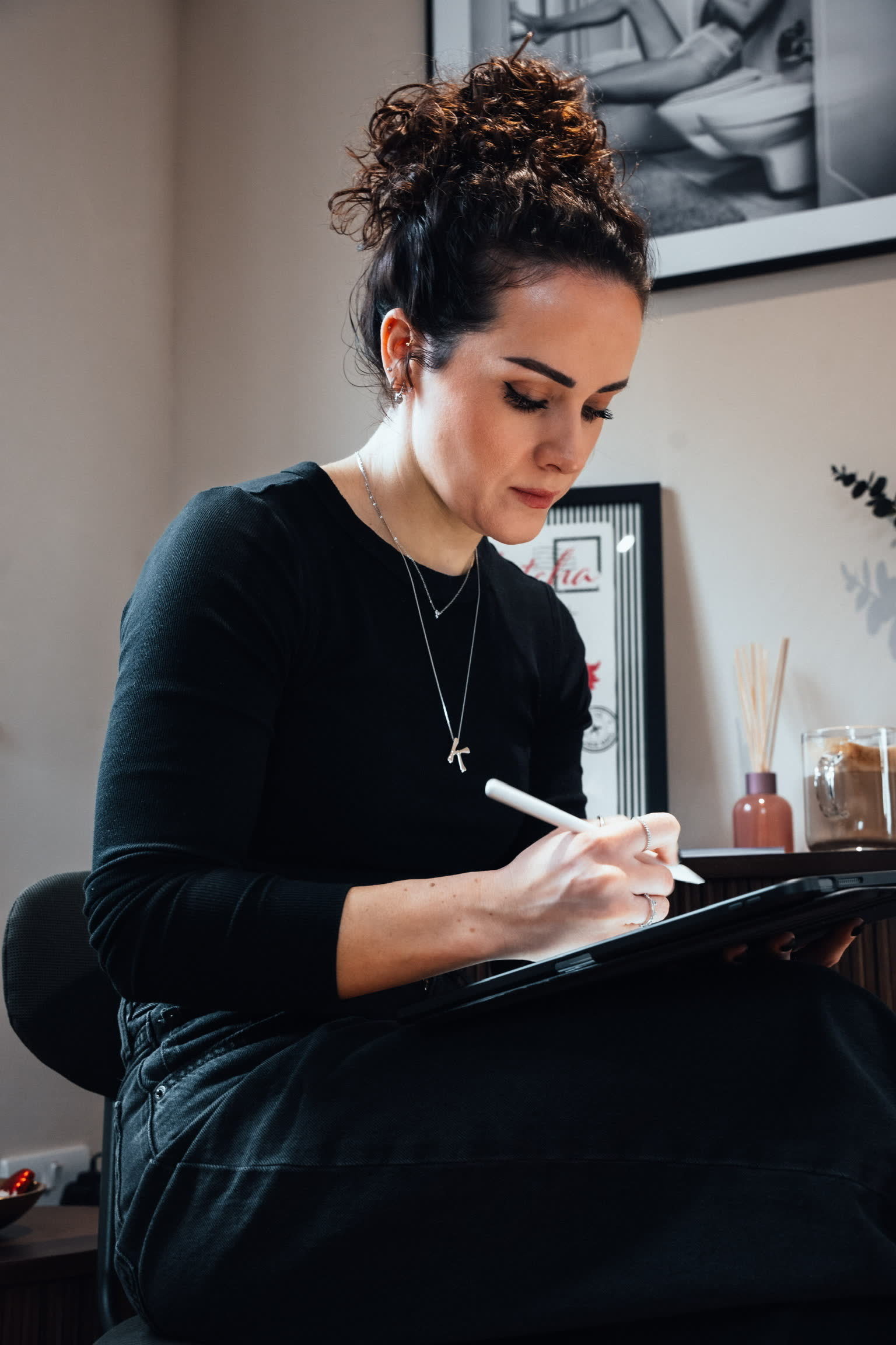 Kayleigh designing fine line work in Procreate on an iPad