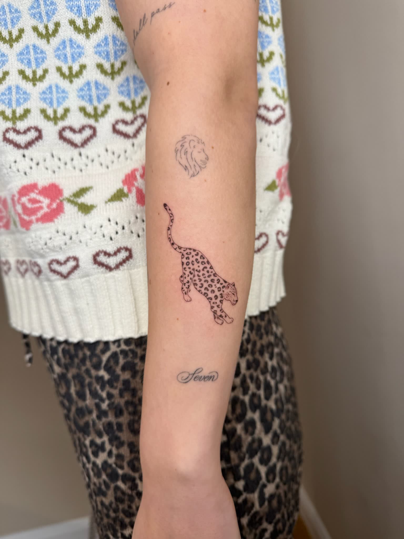A fine line leopard and lion on the forearm